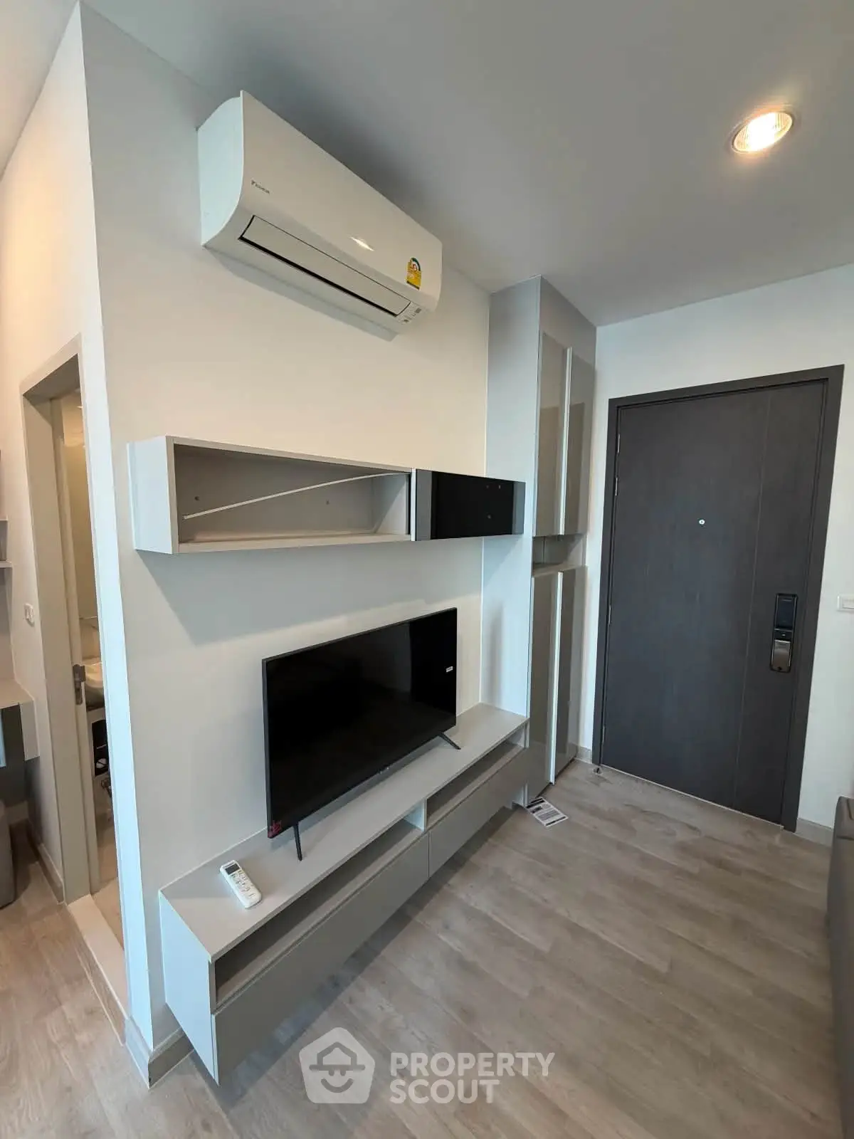 Modern living room with sleek TV unit and air conditioning in a stylish apartment.