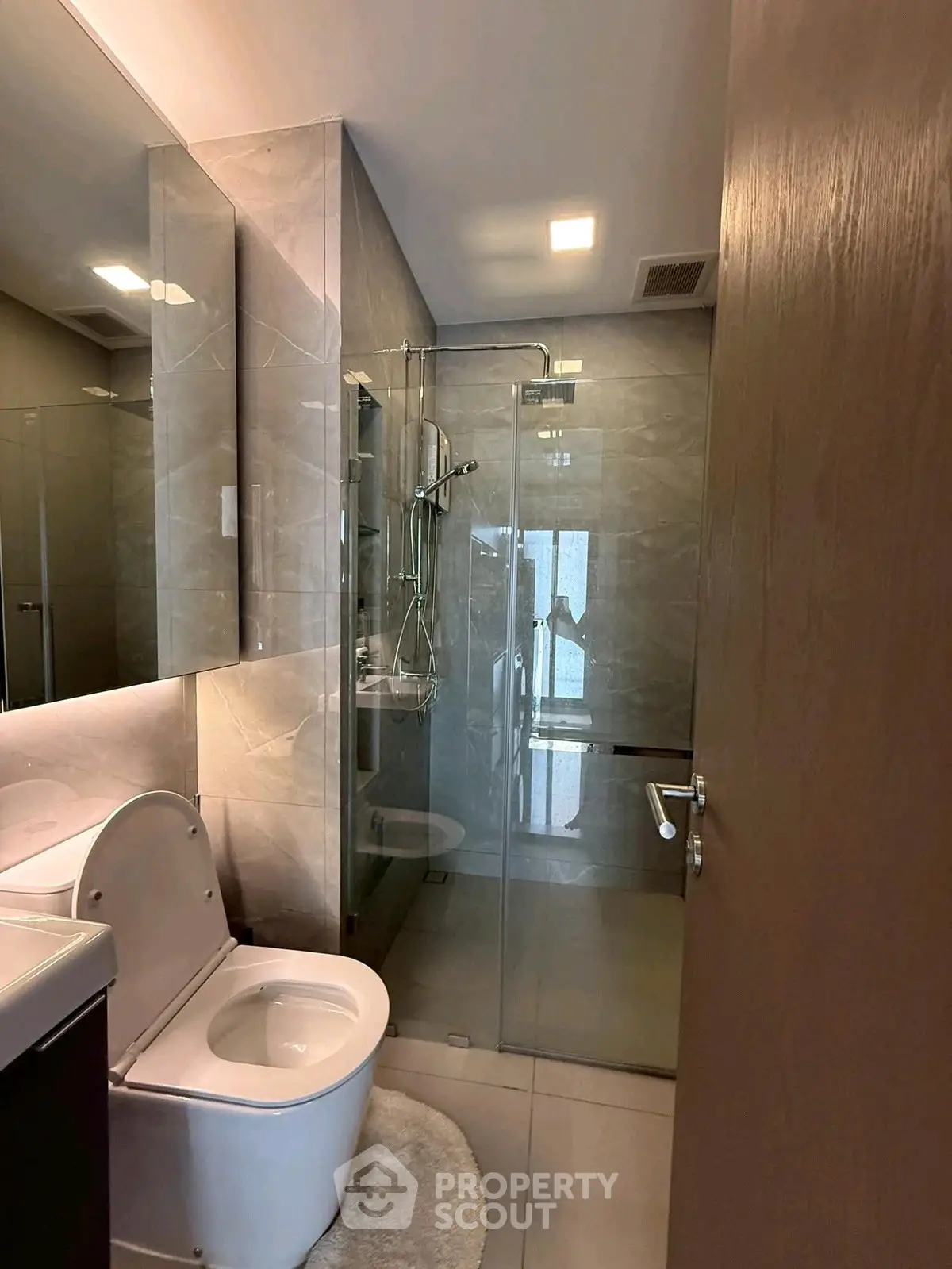 Modern bathroom with glass shower and sleek fixtures in a contemporary apartment.