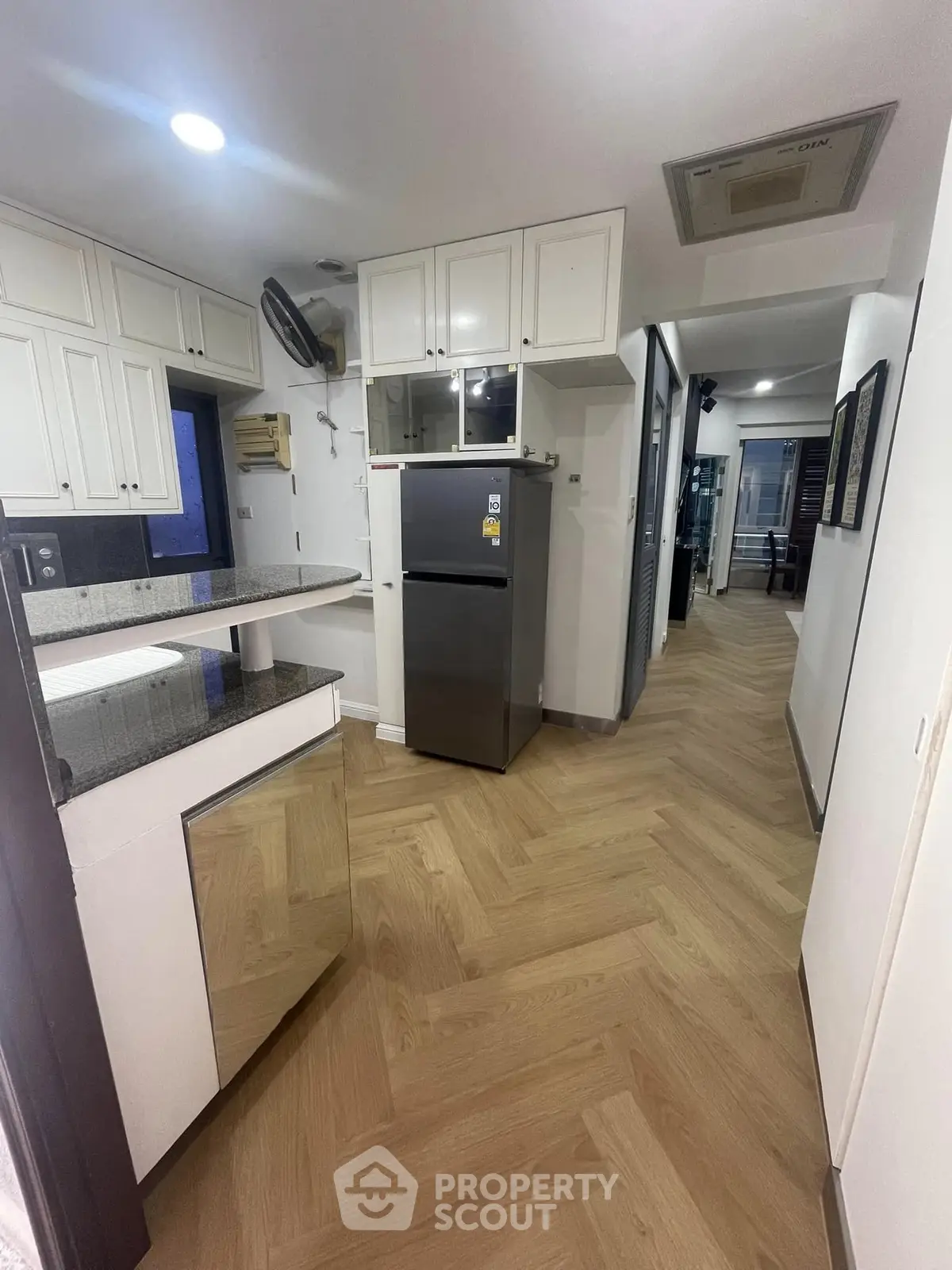 Modern kitchen with sleek design and stainless steel fridge in a contemporary apartment.