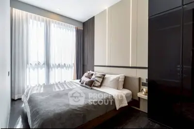 Modern bedroom with sleek design and natural light, featuring a cozy bed and stylish decor.