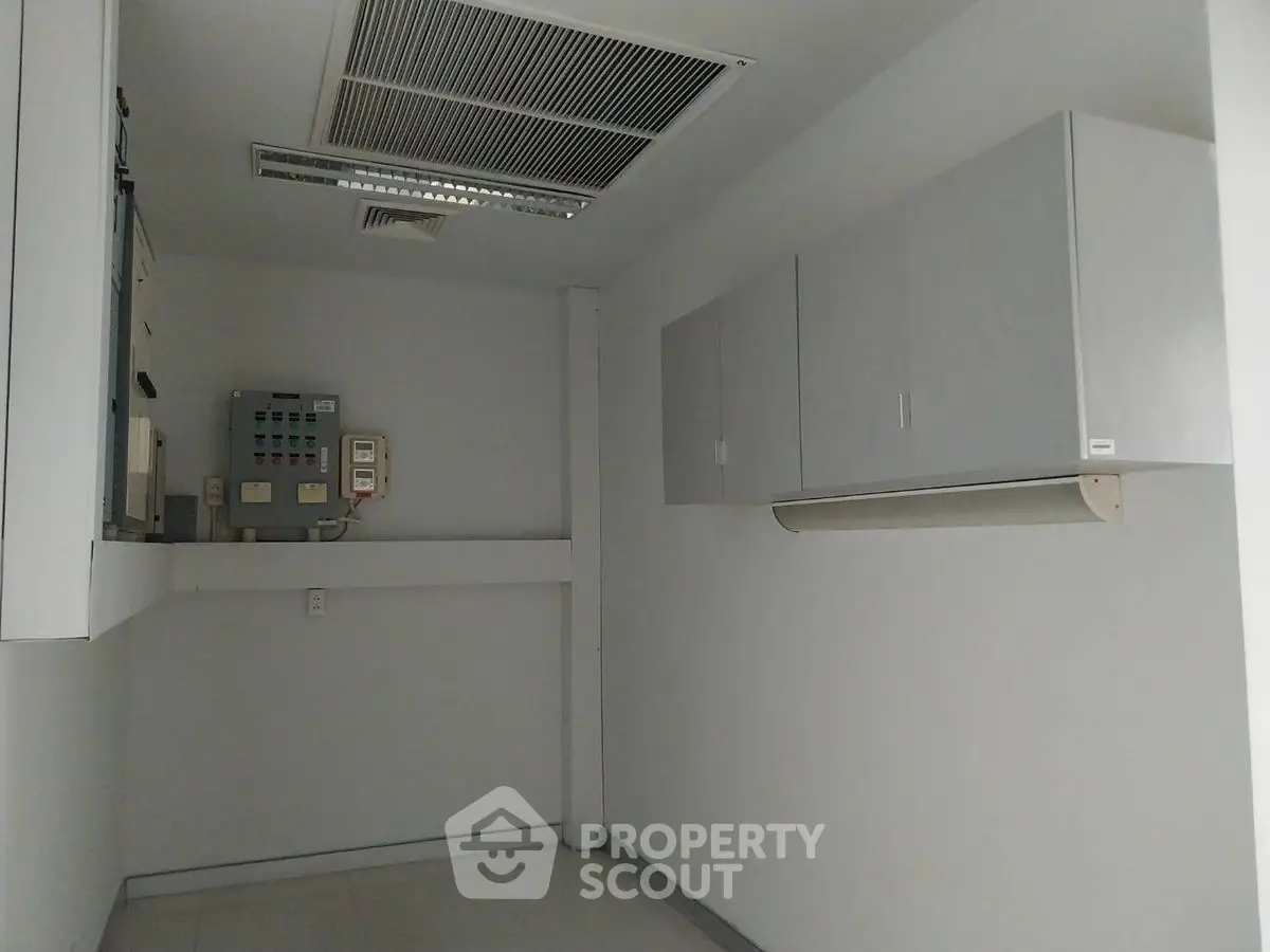 Spacious utility room with modern electrical panel and storage cabinets.
