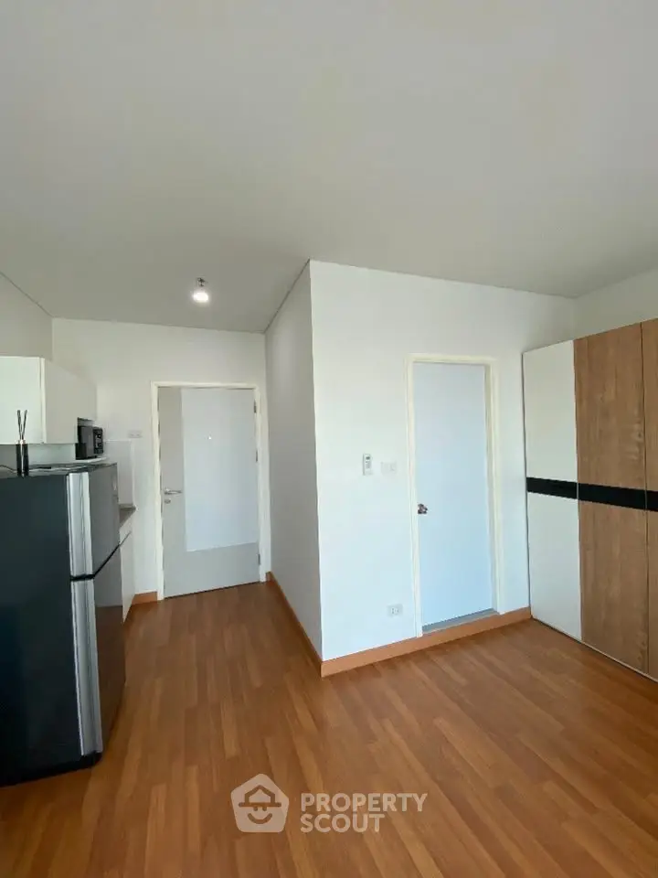 Modern kitchen with sleek appliances and wooden flooring in a stylish apartment.