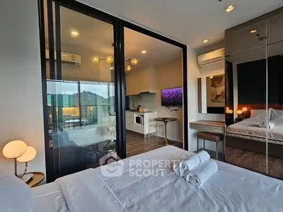 Modern bedroom with glass partition and mountain view, featuring cozy lighting and sleek furnishings.