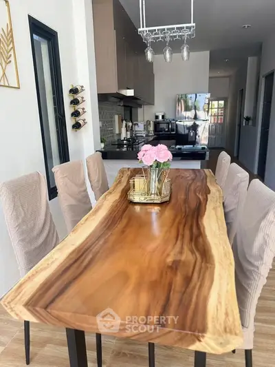 Elegant dining area with natural wood table and modern kitchen in open layout