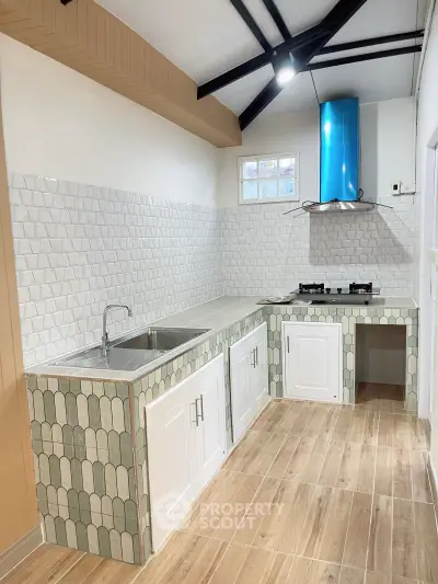 Charming kitchen with unique tile design and gas stove, perfect for culinary enthusiasts.