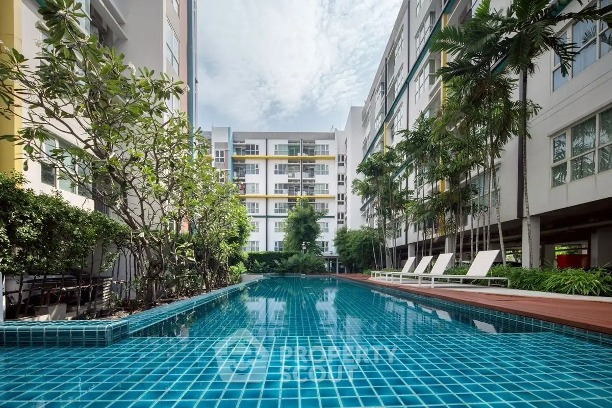 Luxurious apartment complex with a stunning outdoor pool and lush greenery.