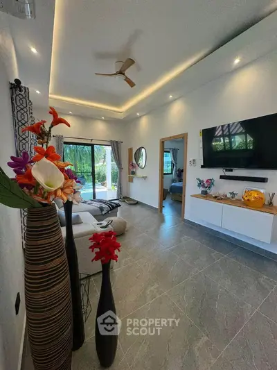 Luxurious living room with modern decor and garden view, featuring elegant lighting and stylish furnishings.