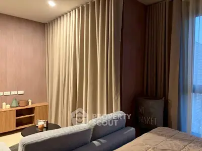 Cozy living room with modern decor and soft lighting, featuring a comfortable sofa and elegant curtains.