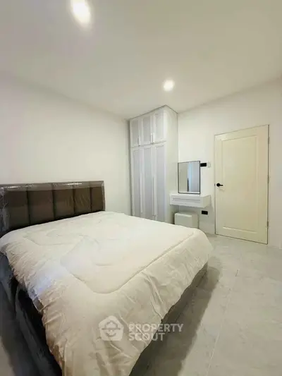 Modern bedroom with sleek design, featuring a comfortable bed and built-in wardrobe, perfect for relaxation.