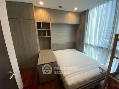 Modern bedroom with built-in storage and large window in a stylish apartment.