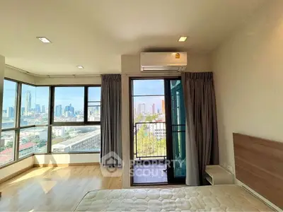 Spacious bedroom with city view and balcony access in modern apartment