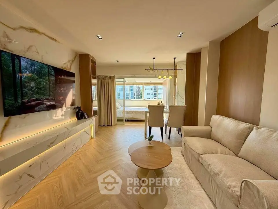 Luxurious open-plan living room with elegant decor and large windows offering a stunning view.