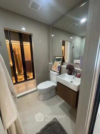 Modern bathroom with sleek design, featuring a large mirror, stylish sink, and elegant decor.