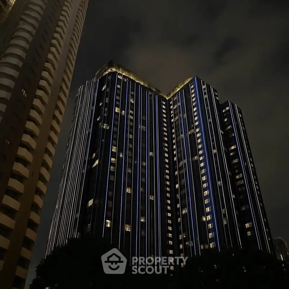 Stunning night view of modern high-rise building with illuminated facade in urban skyline.