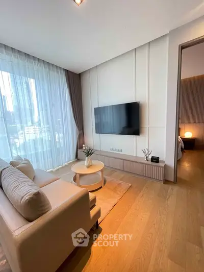 Luxurious living room with modern decor and city view, featuring a sleek TV and elegant furnishings.