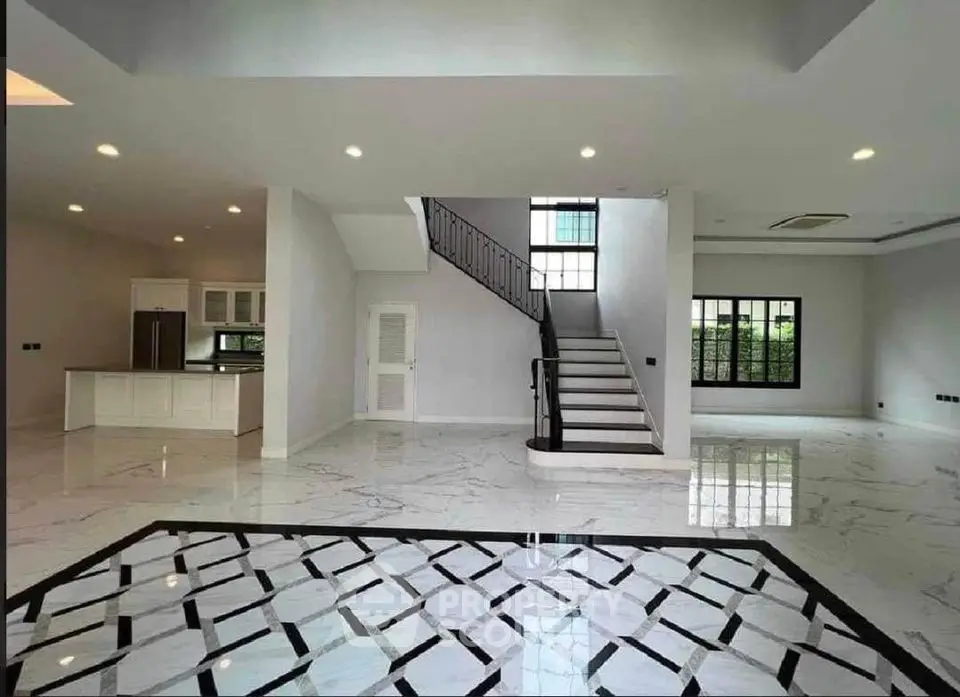 Spacious modern living room with elegant staircase and open kitchen layout