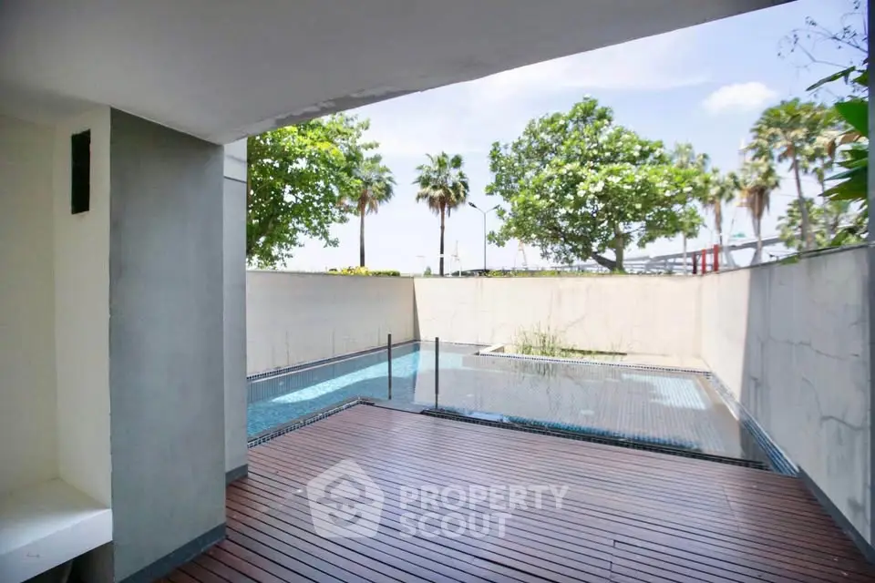 Luxurious private pool area with wooden deck and lush greenery, perfect for relaxation and entertainment.