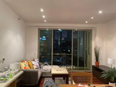 Modern living room with city view, featuring cozy seating and stylish decor, perfect for urban living.