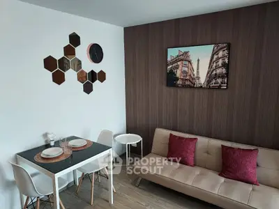 Modern living room with stylish decor and dining area, featuring a cozy sofa and elegant wall art.