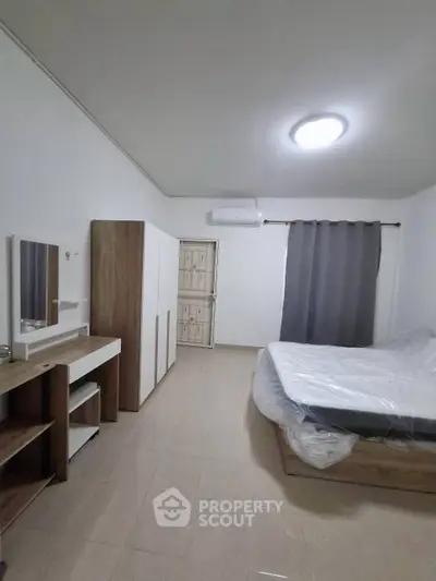 Spacious bedroom with modern furniture and air conditioning, perfect for comfort and relaxation.