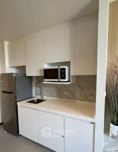 Modern kitchen with sleek white cabinetry and stainless steel appliances