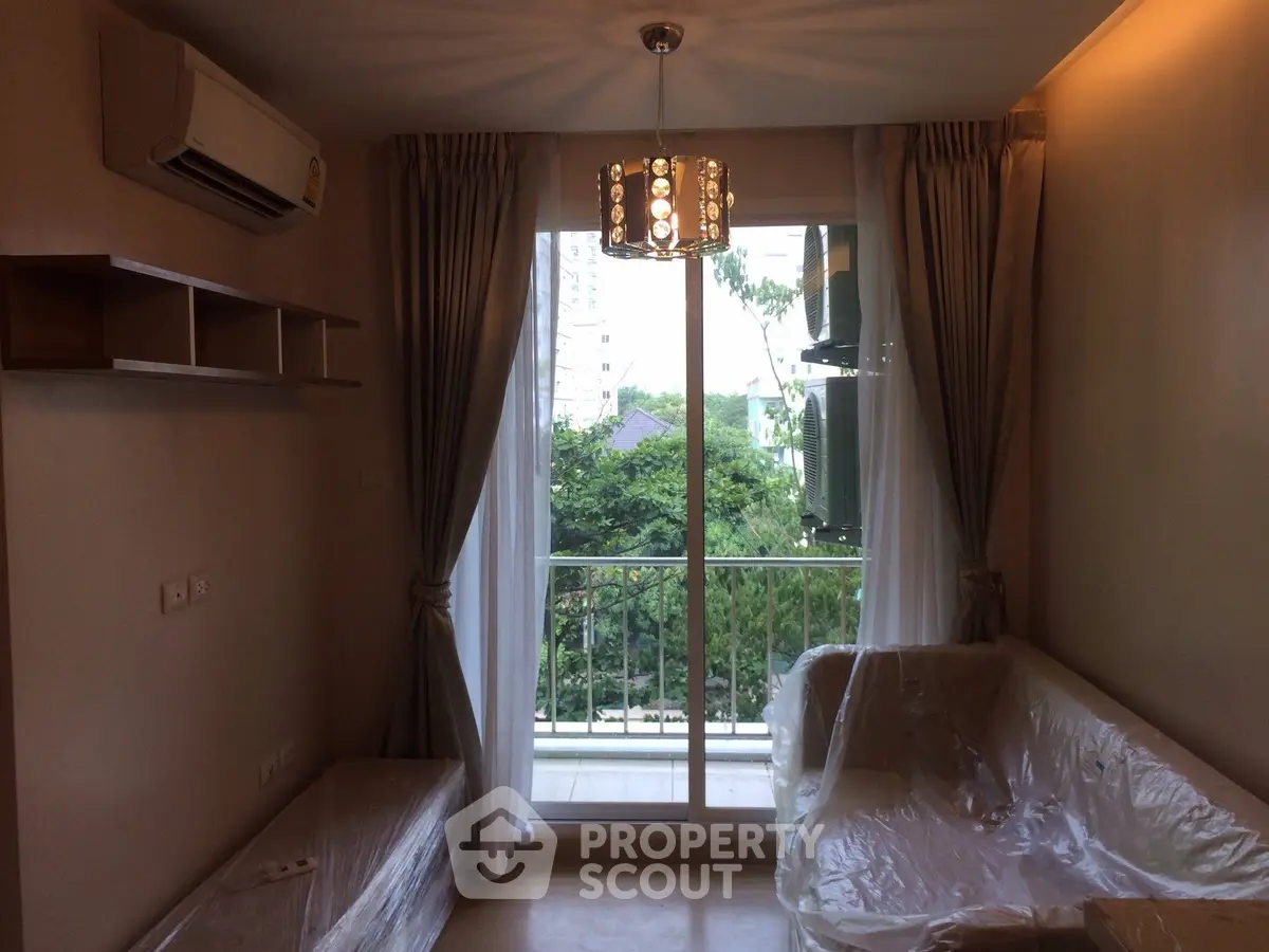 Cozy living room with balcony view, modern lighting, and air conditioning in a stylish apartment.