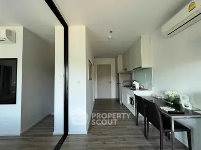 Modern apartment interior with sleek kitchen and dining area, featuring air conditioning and stylish decor.
