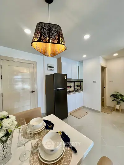 Modern kitchen with elegant dining setup and stylish lighting fixture.