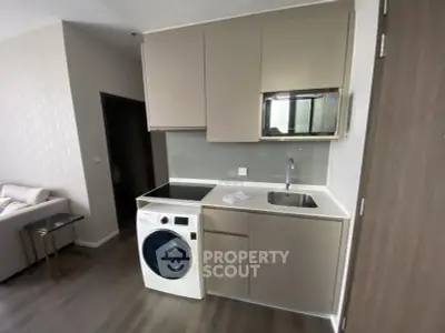 Modern compact kitchen with integrated washing machine and sleek cabinetry