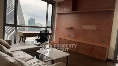 Modern living room with city view, featuring sleek furniture and large windows for natural light.