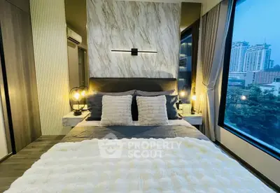Luxurious modern bedroom with large windows offering stunning city views, elegant decor, and ambient lighting.
