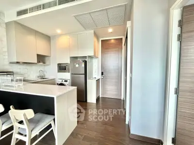 Modern kitchen with sleek appliances and stylish dining area in a contemporary apartment.