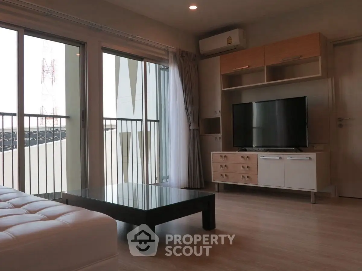 Modern living room with large windows and sleek furniture in a stylish apartment.
