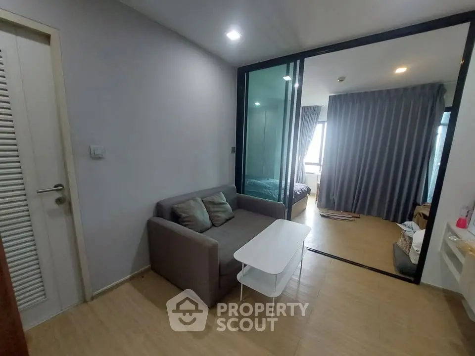 Modern apartment interior with cozy living area and bedroom, featuring sleek design and natural light.