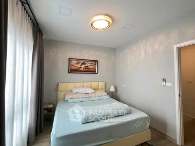 Cozy bedroom with modern decor and soft lighting, featuring a comfortable bed and elegant curtains.
