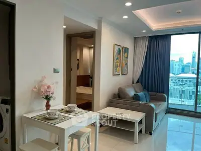 Modern living room with city view, cozy seating, and elegant dining area in a high-rise apartment.