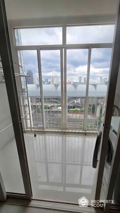 Modern balcony with city view and laundry area in high-rise apartment