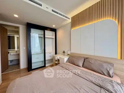 Modern bedroom with stylish lighting and built-in closet, featuring a cozy bed and elegant decor.