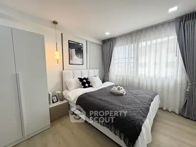 Modern bedroom with stylish decor and large windows for natural light.