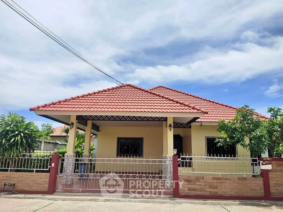 Charming single-story house with red tile roof and gated front yard.