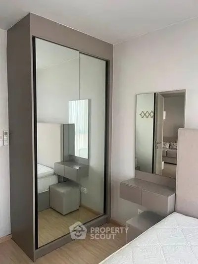 Modern bedroom with sleek mirrored wardrobe and minimalist decor