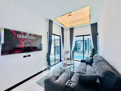 Modern living room with stylish sofa and large windows overlooking a pool, featuring a sleek TV setup.