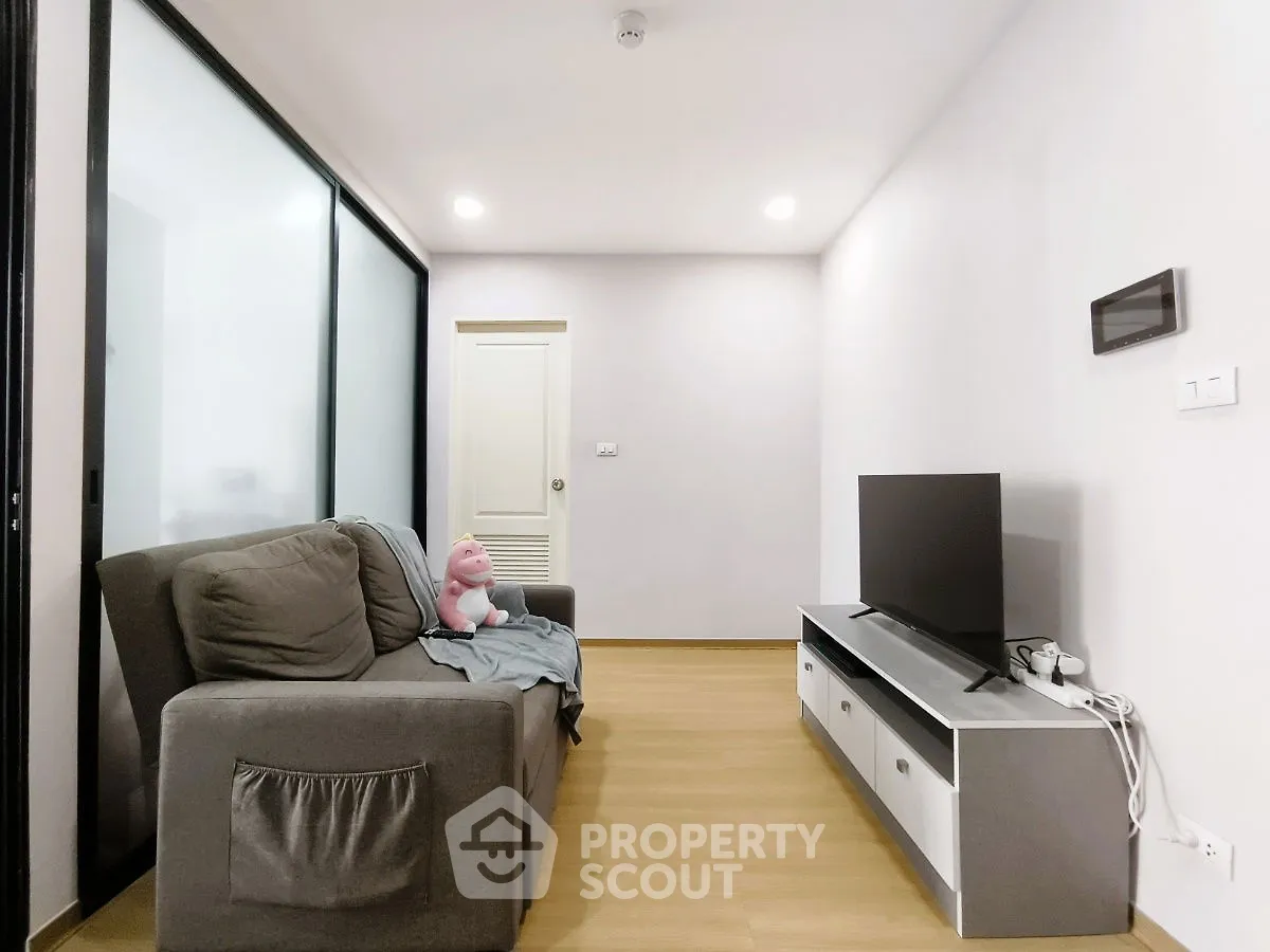 Modern living room with sleek TV stand and cozy sofa in minimalist apartment.