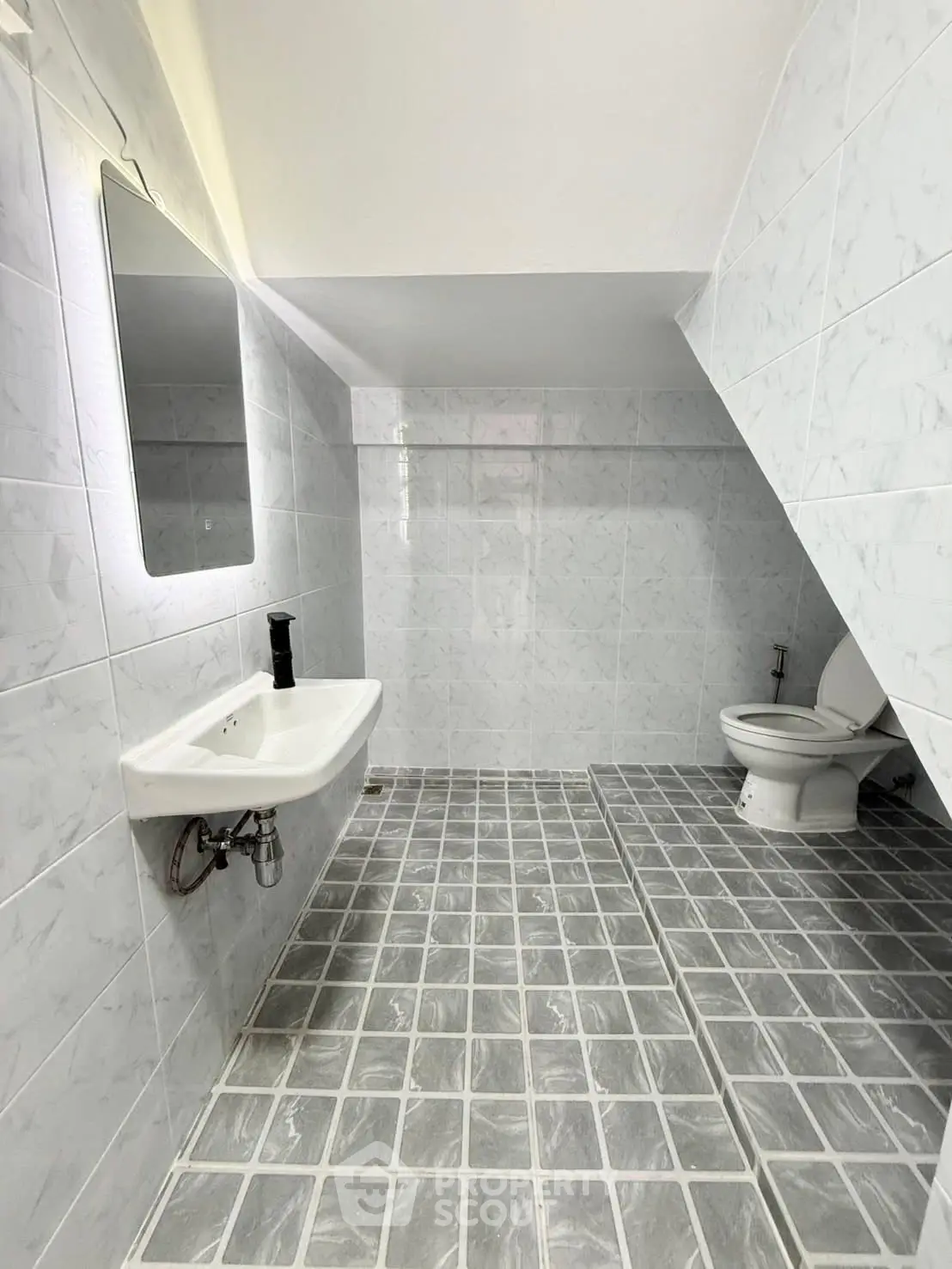 Spacious modern bathroom with sleek white tiles and minimalist fixtures