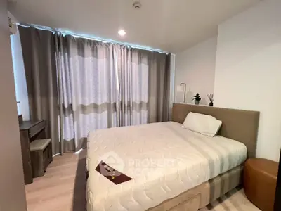 Modern bedroom with stylish decor and natural light, featuring a comfortable bed and elegant curtains.