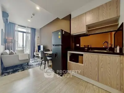 Modern open-plan living room and kitchen with stylish decor and natural light.
