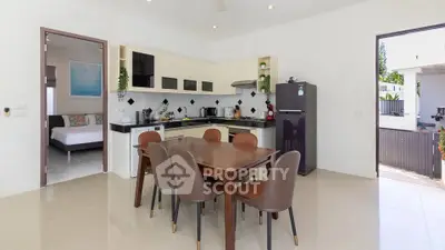 Modern kitchen with dining area and open layout, featuring sleek appliances and stylish decor.