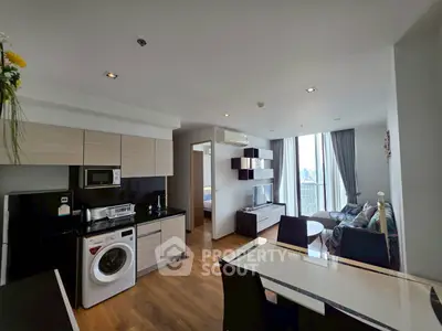 Modern open-plan living room with kitchen, dining area, and city view.