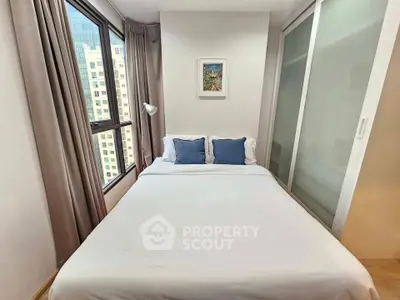 Cozy bedroom with city view, featuring a comfortable bed and modern decor in a high-rise apartment.