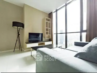 Modern living room with large windows and city view, featuring sleek furniture and neutral tones.